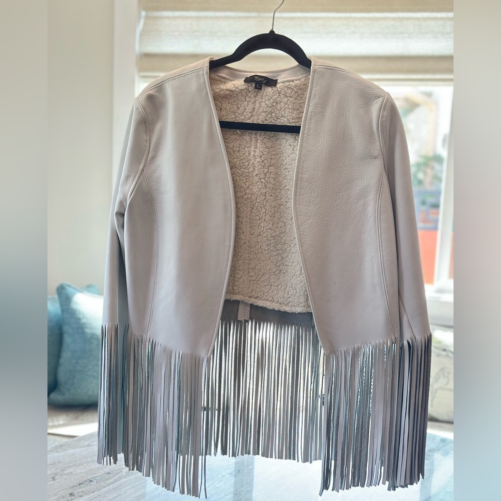 Sky white leather jacket with fringe.